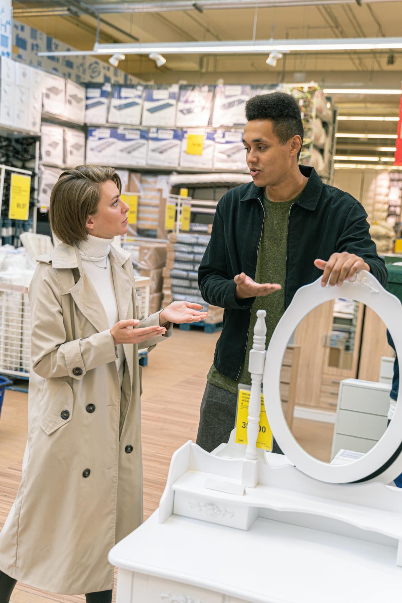 Two adults conversing over a product in a bustling retail environment.